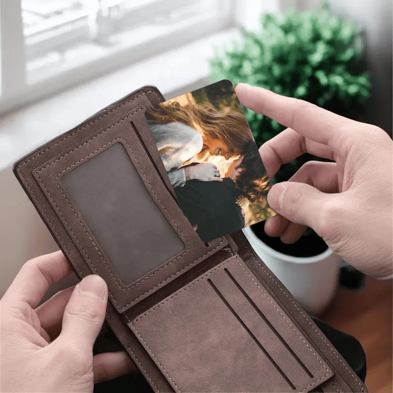 Custom photo wallet card being placed in a leather wallet